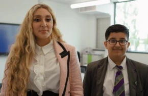 Pupil and teacher standing together in classroom