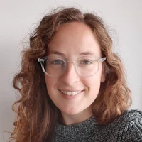 Female with curly hair wearing glasses