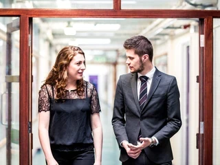 two teachers talk and walk down corridor